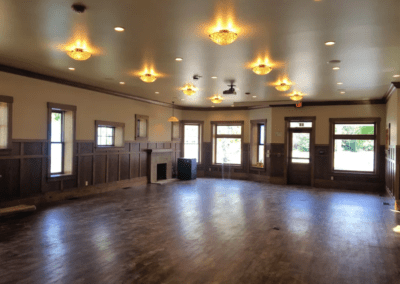 An empty room with wood paneling and ceiling lights.