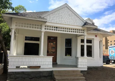 A white house with a porch and steps.