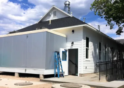 A white building with a roof on it.