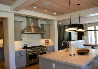 A kitchen with gray cabinets and wooden ceilings.