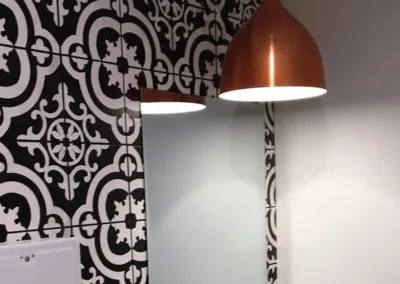 A bathroom with a black and white tiled wall.