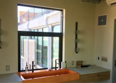 A kitchen with an orange sink and a window.