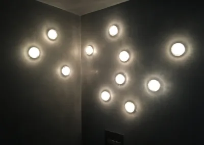 A bathroom with a lot of lights on the wall.