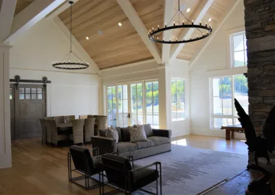 A living room with wood beams and a stone fireplace.